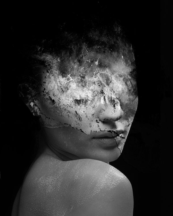 Rise Above the Waters is a black and white portrait of a woman blended with waves crashing onto a reef, from an upper angle, her face obscured by the foam